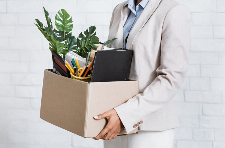 A person holding a box of office goods